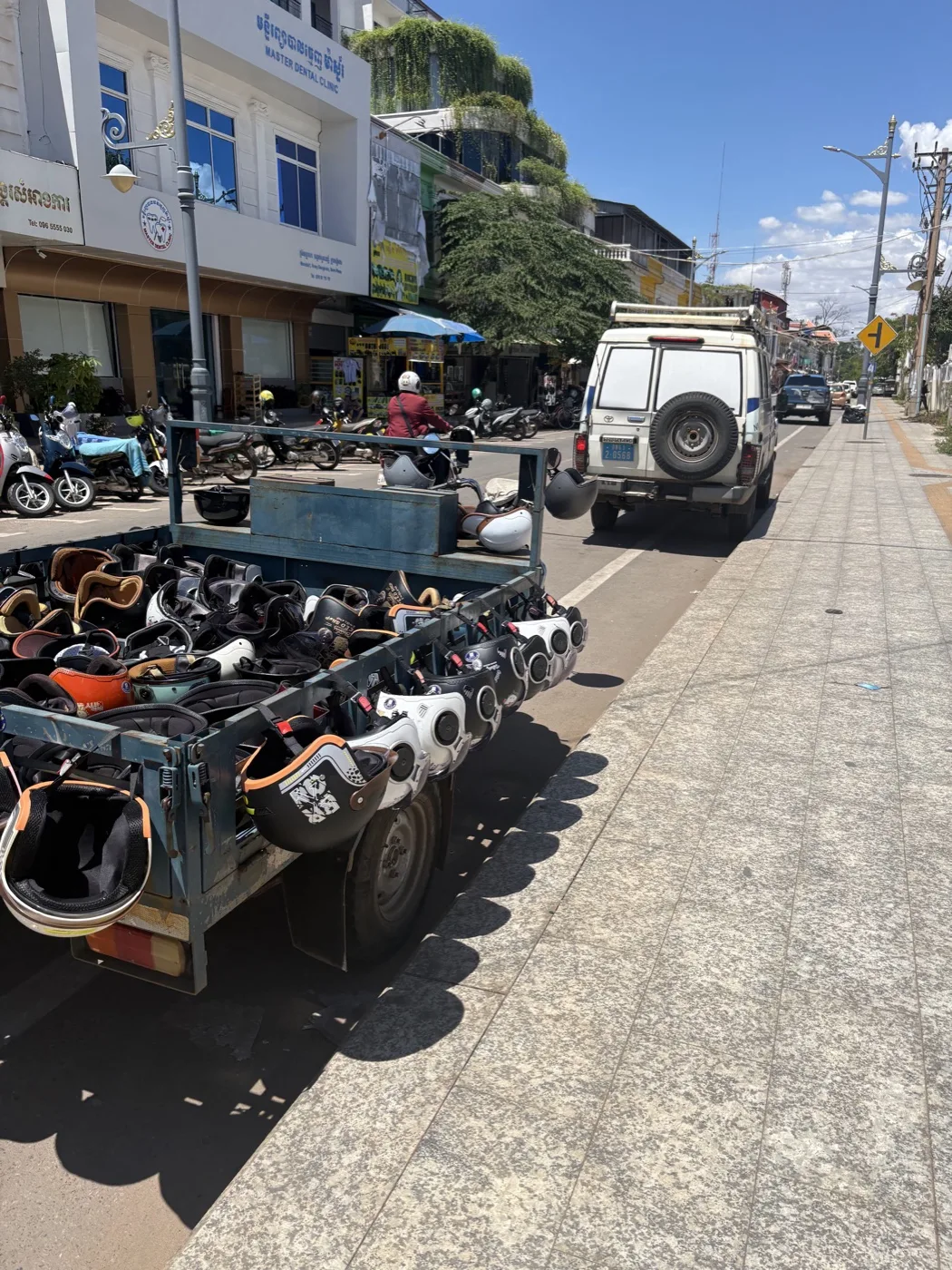 Street view of helmet distribution cart on a sunny Cambodian day