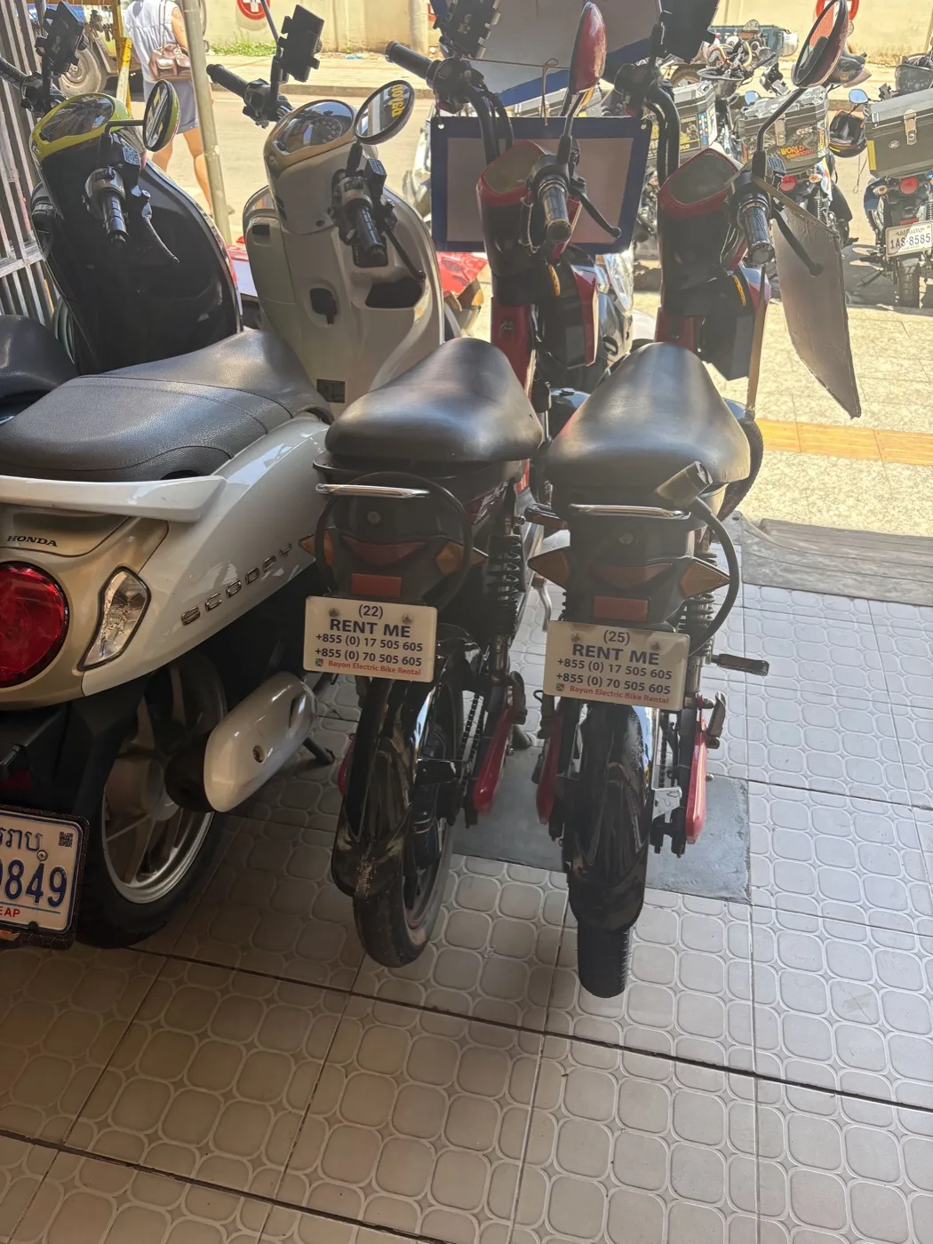 Wide view of helmet cart with shops and motorcycles in background