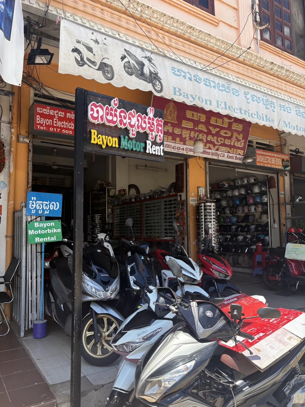Rows of motorcycle helmets with price tags at a street market