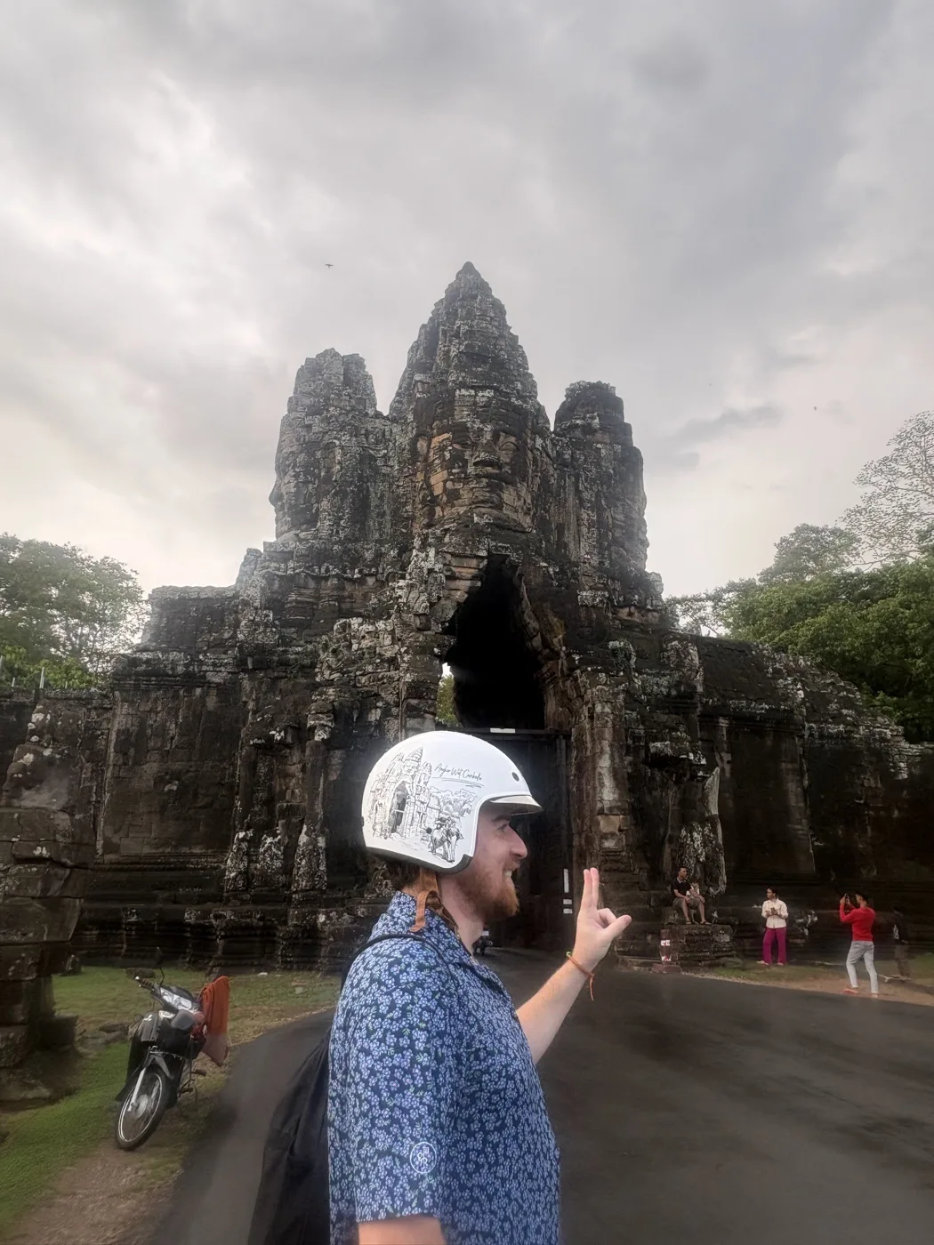 Jim wearing a white decorated helmet at the entrance to Bayon Temple
