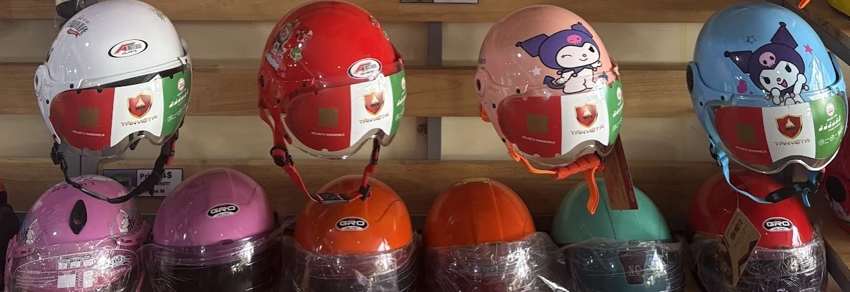 Row of certified child helmets with cartoon designs ready for distribution in Cambodia