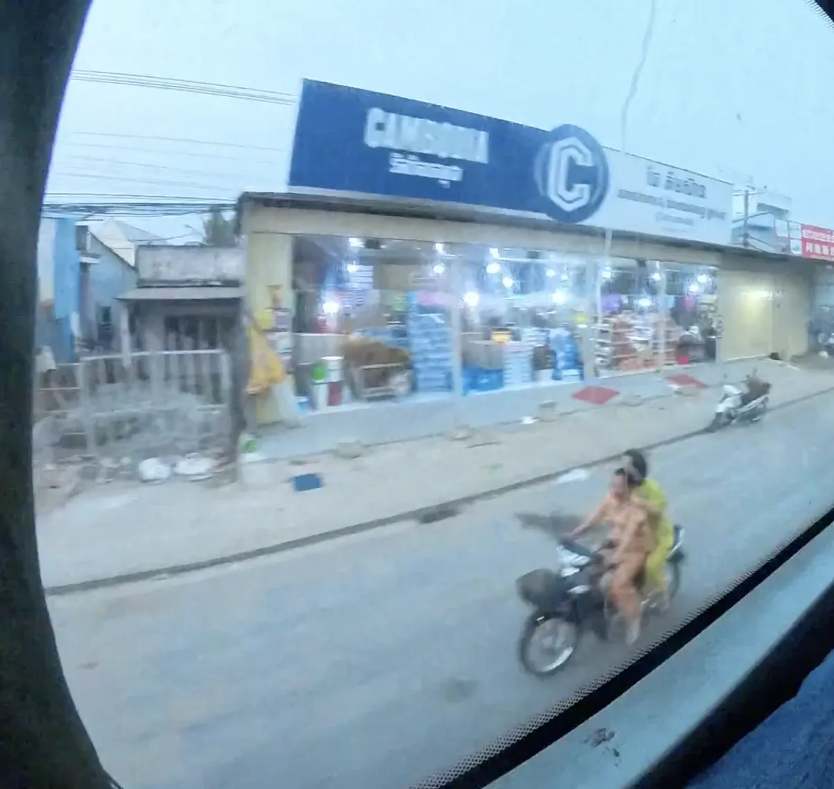 Cambodian road with multiple motorcyclists, none wearing helmets