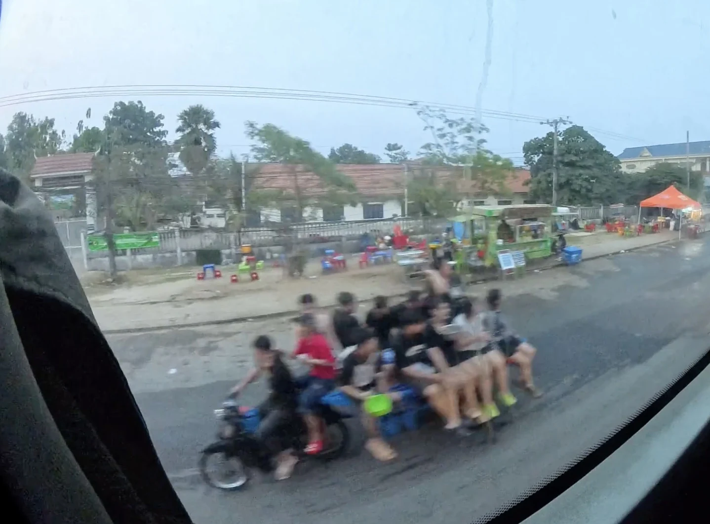 Overcrowded motorcycle carrying multiple passengers in Cambodia