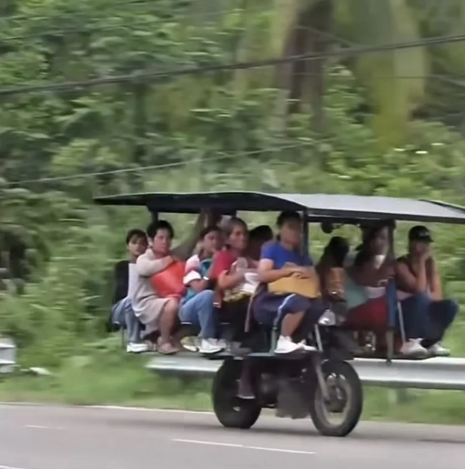 Overcrowded open-air passenger vehicle traveling on a public road